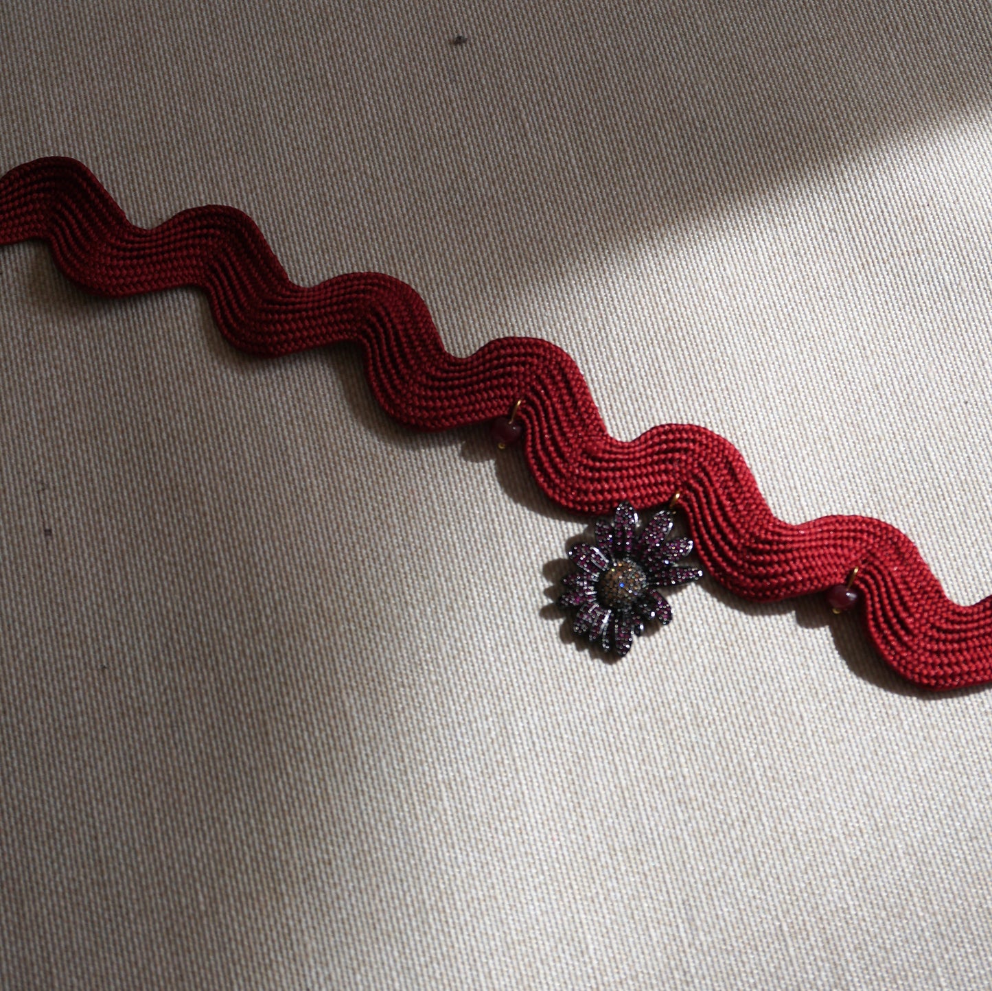 Girocollo ondulato bordeaux con fiore