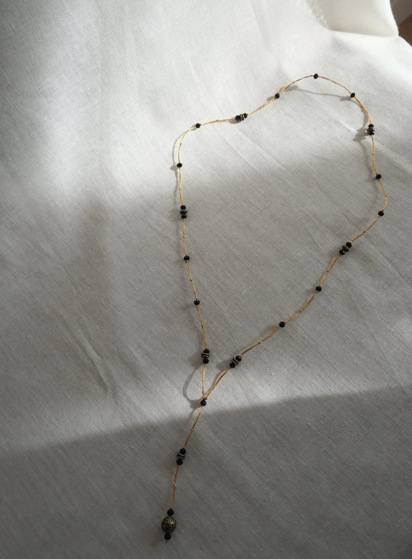 Collana lunga con elemento in bronzo