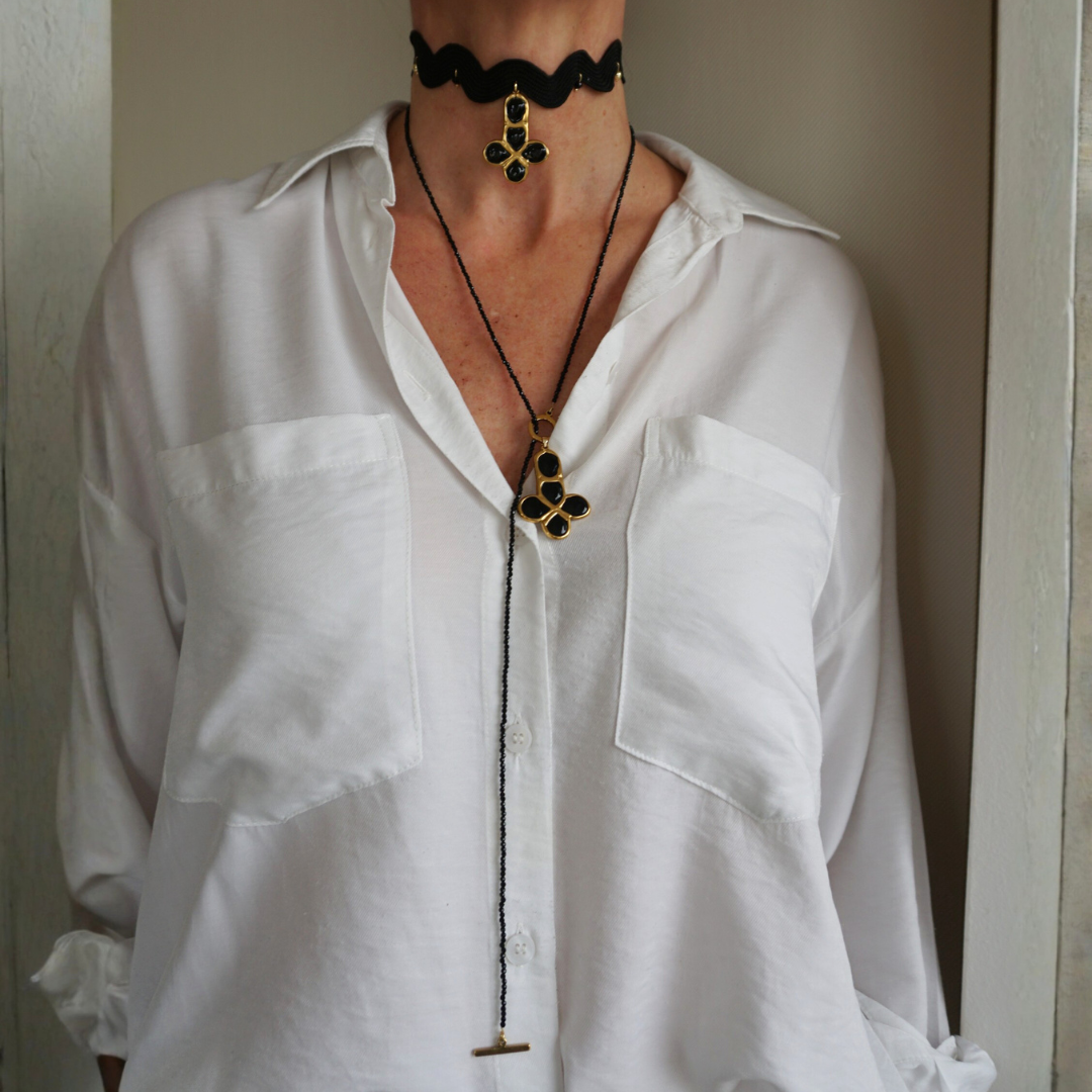 Tira larga de piedras y cruz dorada de piedras negras