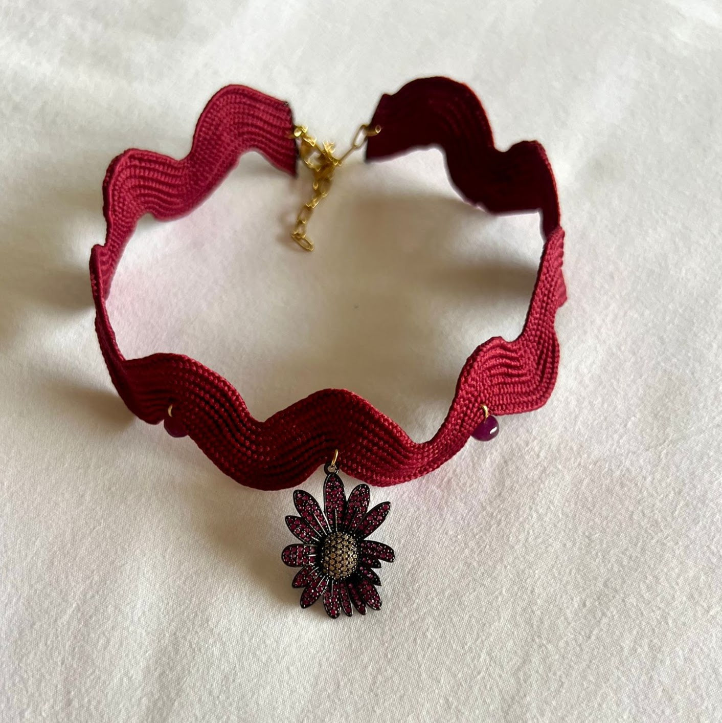 Girocollo ondulato bordeaux con fiore