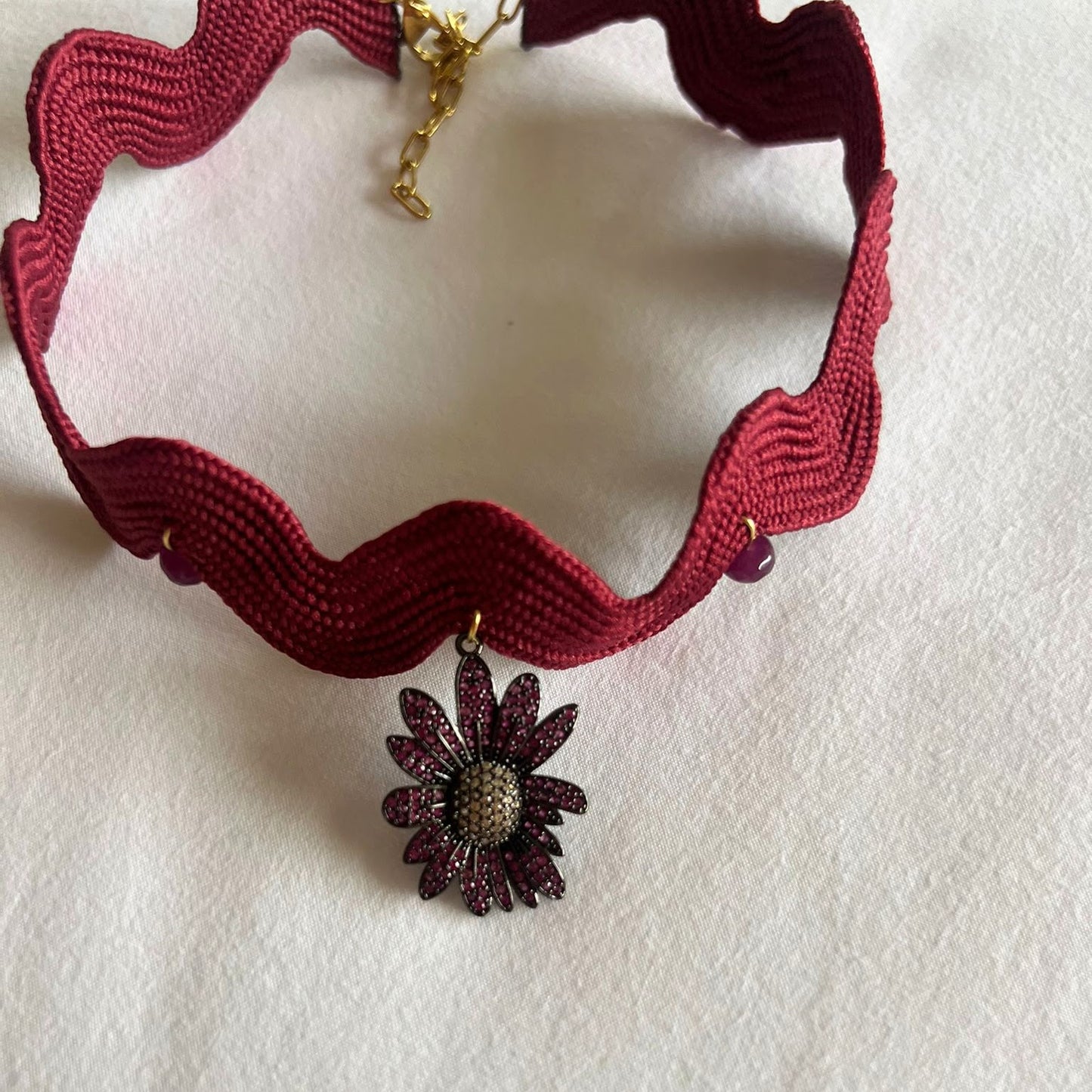 Girocollo ondulato bordeaux con fiore
